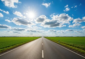 Fototapeta premium Straight asphalt road stretches through green fields under a sunny, cloudy sky