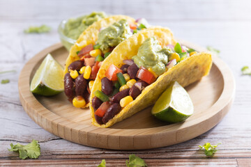 Vegan mexican Taco with beans and guacamole on wooden table