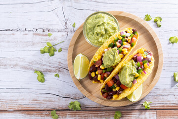 Vegan mexican Taco with beans and guacamole on wooden table. Top view. Copy space