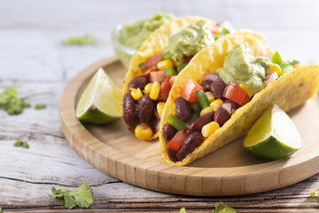 Vegan mexican Taco with beans and guacamole on wooden table