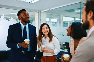 Happy multi-ethnic business people enjoying coffee break in office