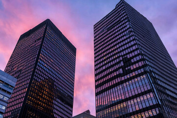 Obraz premium Silhouette of skyscrapers at sunset with colorful sky backdrop