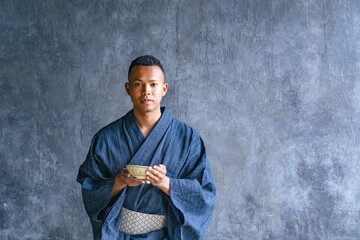 A black man wearing a yukata and experiencing a Japanese tea ceremony