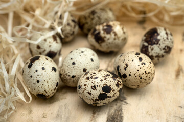 close-up of spotted, quail eggs surrounded by decorative straw
