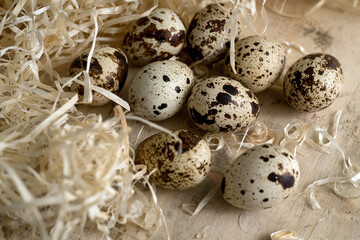 spotted, quail eggs close-up surrounded by decorative straw, rustic coziness