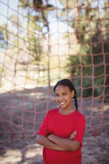 Rope climbing net standing among trees and casting patterned shadows on dirt ground, copy space