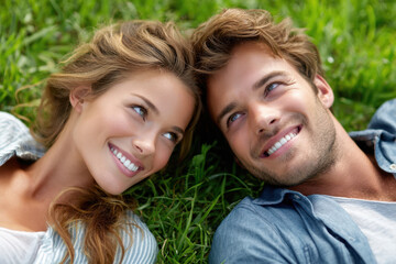 Fototapeta premium Couple enjoying a sunny day on the grass while smiling at each other in a park