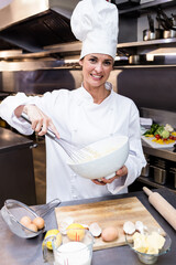 Chef is whisking batter in mixing bowl in professional kitchen with milk jug, butter and eggshells © WavebreakMediaMicro