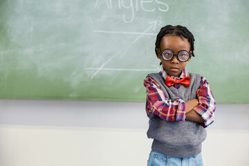 Student is standing confidently in front of green chalkboard showing angles diagrams in classroom © WavebreakMediaMicro