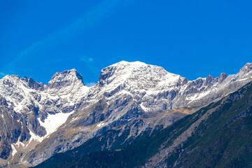 Alpine mountain landscape panorama of Lechtal Austria blue sky and snow.
