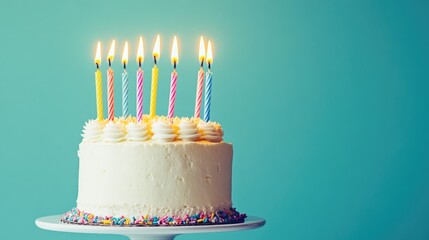 Candles atop birthday cake against blue backdrop.