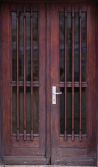 Dark wooden doors. Metal bars. Vintage style.