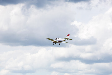 Light aircraft flying in mid-air against a background of dramatic clouds. General aviation concept, transportation, private flight.