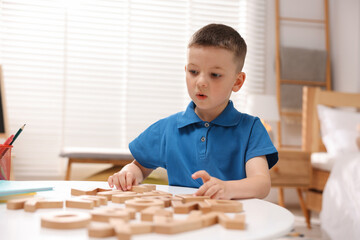 Dyslexia. Little boy learning letters at table indoors