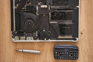 Obraz premium This is a closeup view of a disassembled laptop along with various repair tools arranged on a wooden table