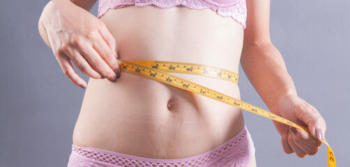 young woman in lingerie with measure tape
