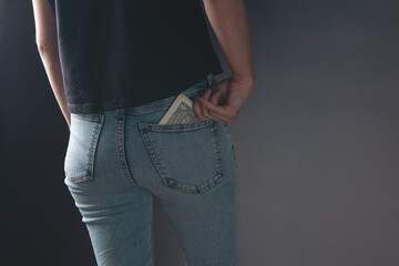 woman withdraws money from her back pocket