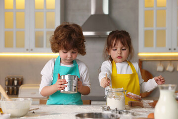Cooking recipe. Cute children sieving flour at table in kitchen
