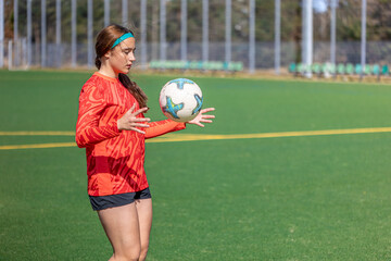 Girl on the soccer field. Soccer training. Active lifestyle. Football concept.