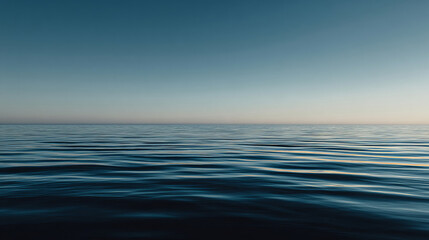 Tranquil ocean horizon beneath a clear blue sky at dawn