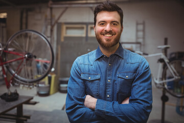 Bicycle frames undergoing repair on stands in workshop, with scattered tools and ladder leaning