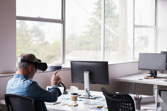 Virtual reality headset projecting interface over laptop and coffee cup near sunlit office windows