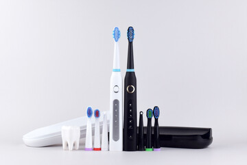 Modern electric ultrasonic toothbrush with rechargeable battery on a gray surface.
