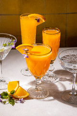 Refreshing orange cocktails garnished with edible flowers and orange slices