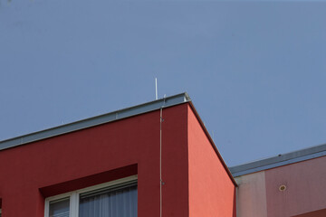 A striking red building stands prominently, with a vivid blue sky serving as a picturesque backdrop that enhances its features
