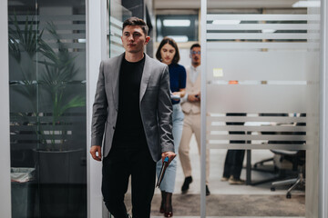 A confident businessman in a suit leads two colleagues through a sleek, modern office corridor. The focus is on teamwork and leadership in a employee business environment.