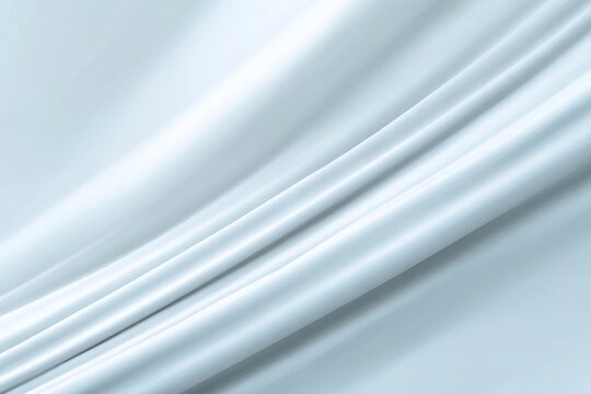 A textured white fabric drapes diagonally creating soft folds and highlights