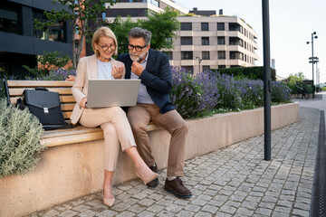 Business people, laptop and collaboration for research outdoor for website review and reading...