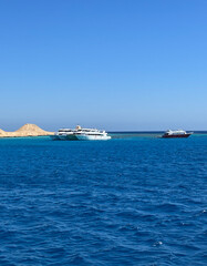 Yachts on the horizon of the blue sea and clear sky on a sunny summer day, vacation, vacation, sailing on a ship. High quality photo