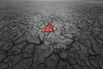 Cracked Earth Surface with Warning Sign for Climate Change Awareness. World Day to Combat Desertification and Drought (June 17)