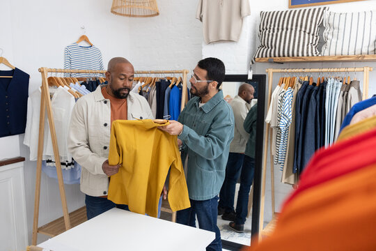 Salesperson Shows Yellow Shirt to Customer