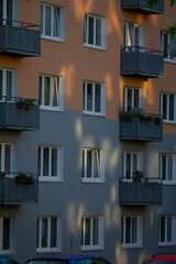 A striking building featuring numerous windows along with several balconies, creating a vibrant urban atmosphere that enhances the living experience