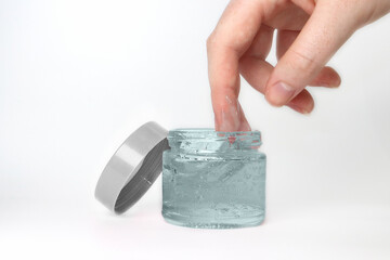 make up container with lid and gel product or cream and hand showing product
