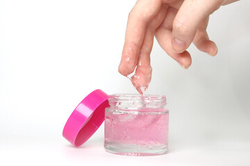 make up container with pink lid and gel pink product or cream and hand showing product