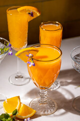 Refreshing orange cocktails garnished with edible flowers and orange slices