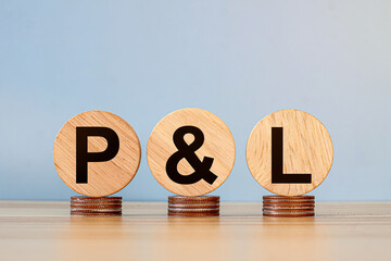P L letters on wooden cubes and US dollar bills background. profit and loss concept