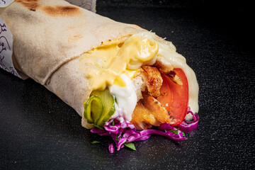 A delicious wrap showcases tender chicken, vibrant vegetables, and a drizzle of creamy sauce