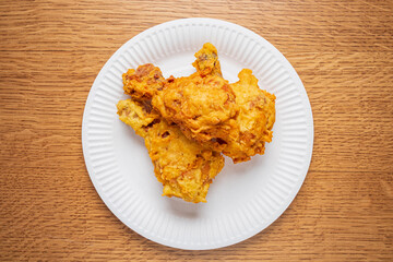 A plate holds succulent pieces of fried chicken, golden and crispy, creating an inviting atmosphere