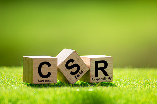 CSR (coporate social responsibility). words CSR on a woodblock and green world on a green background It is an idea for Corporate social responsibility and society activity concept. - Powered by Adobe