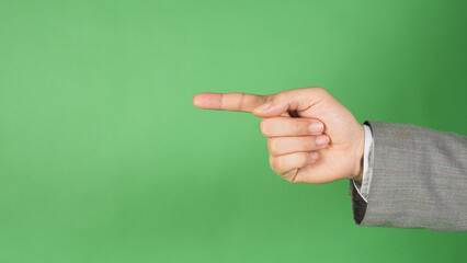 a hand in a gray suit and pointing with the index finger on green screen background.