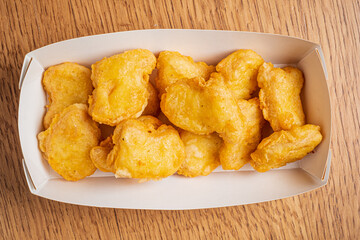 Crispy golden treats fill a cozy box, inviting everyone to enjoy a delightful snack