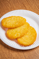 Deliciously crispy hash browns arranged neatly on a paper plate, perfect for a filling meal
