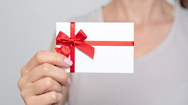 Elegant gift card presentation with vibrant red bow and clean modern design