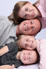 Happy family posing on light grey background