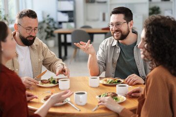 Colleagues chatting during lunch break in office