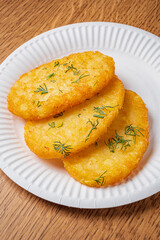 Crispy hash browns with fresh herbs on a white plate invite a warm breakfast experience